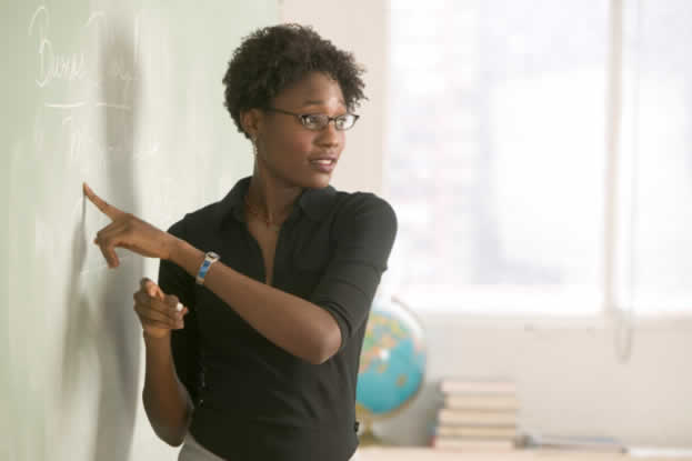 teacher pointing to something on the chalkboard